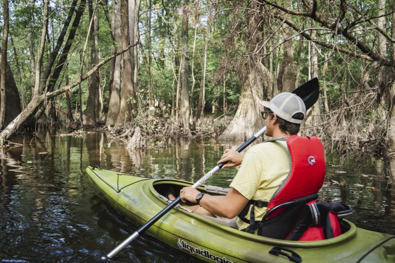Man Kayaking on River