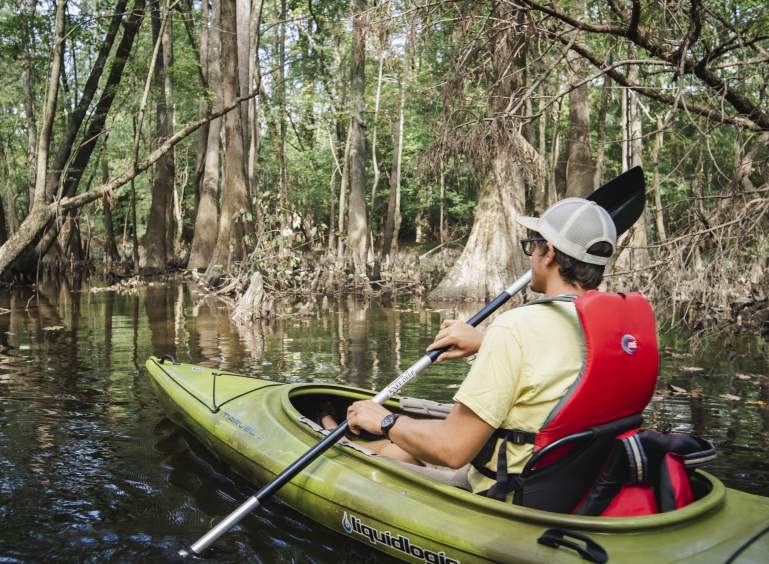 Man Kayaking on River